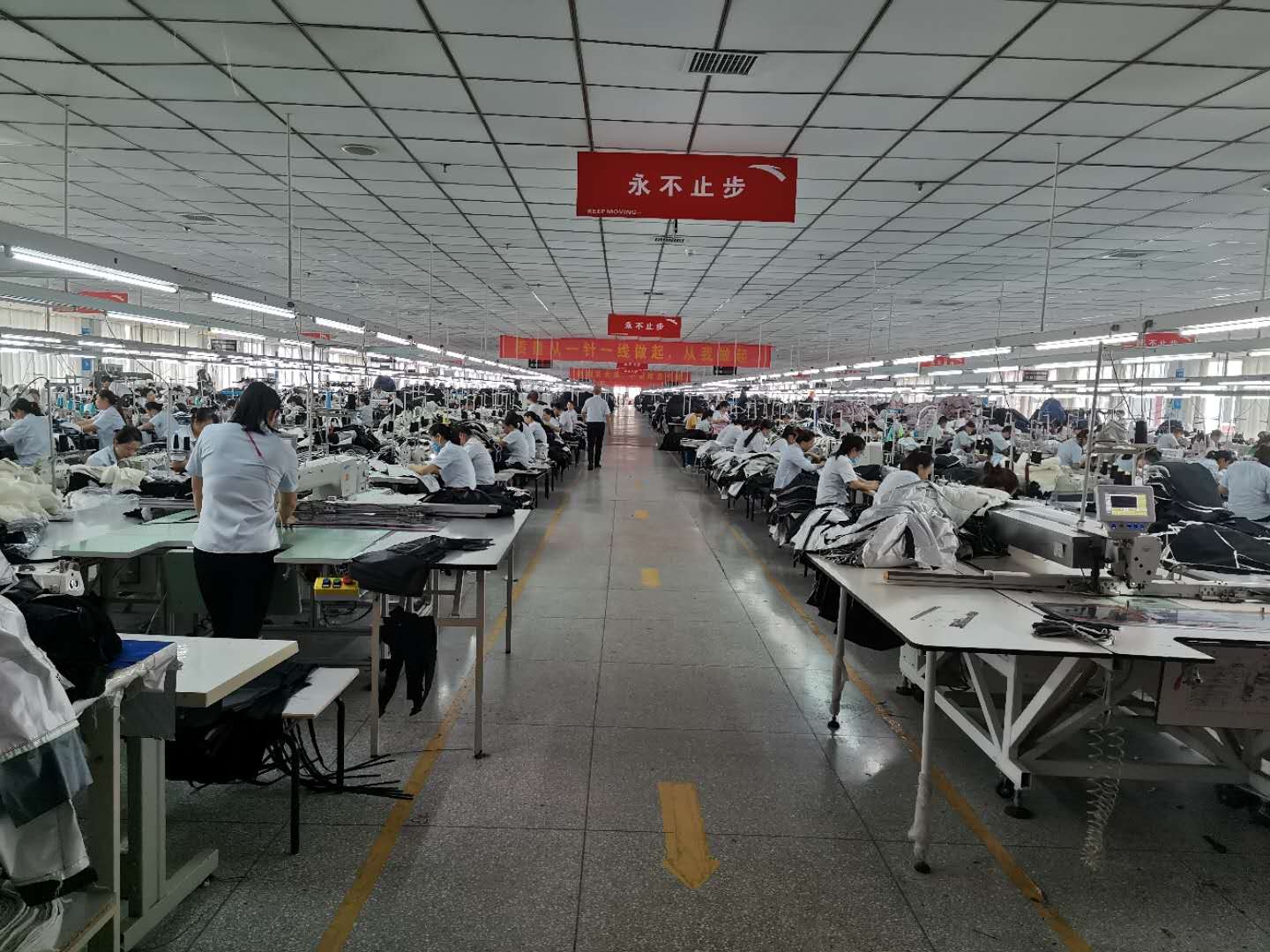 员工在缝制工位工作，展示制作现场而非检验现场